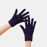 Paire de gants tricoté bleu marine sur des mains.