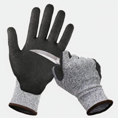 2 mains portant des gants gris et noir, une main tient un couteau dont la lame touche la paume de l'autre main