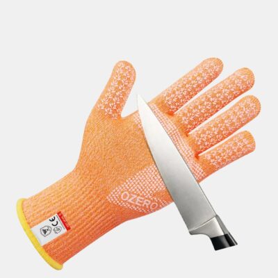 Un gant orange avec une lame de couteauposé sur l'intérieur de la main