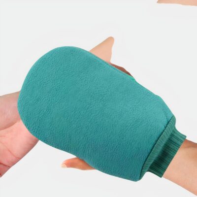 Personne se frottant le bras avec un gant de douche vert.