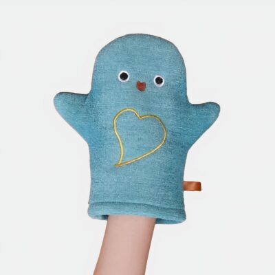 On voit une main dans un gant de toilette bébé bleu motif hibou avec un cœur doré dessus.