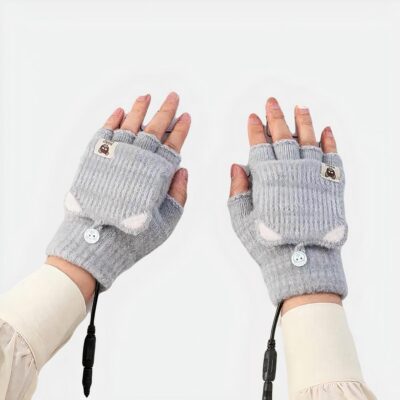 Gants chauffants gris déclinables en mitaines sur un clavier d'ordinateur