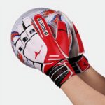 Personne tenant un ballon et portant des gants.