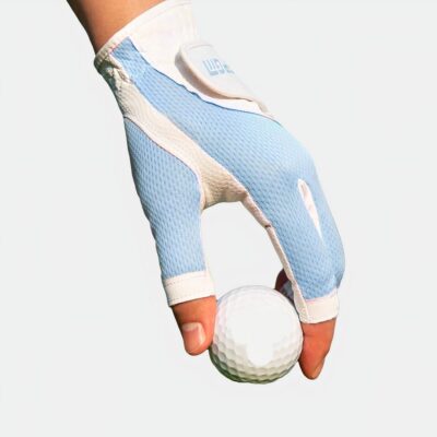 Photo d'une main de golfeuse portant un gant mitaine bleu et blanc et tenant une balle sur le green entre le pouce et l'index