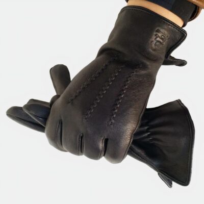 Main portant un gant en cuir et tenant le second gant.