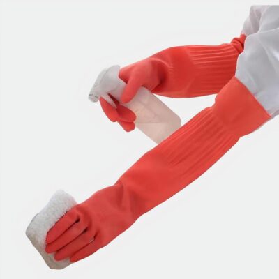 Personne portant des gants longs oranges et nettoyant un évier.