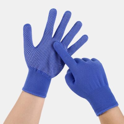 Photo d'une paire de gants bleus anti-chaleur sur des mains de jeune femme, l'un paume ouverte et l'autre montrant les pics de silicone avec l'index, le tout sur fond blanc