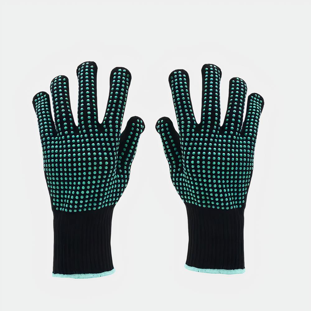 Gants anti-chaleur polyvalents Photo d'une paire de gants anti chaleur noirs à points en silicone verts et liseré de poignet vert sur un fond blanc
