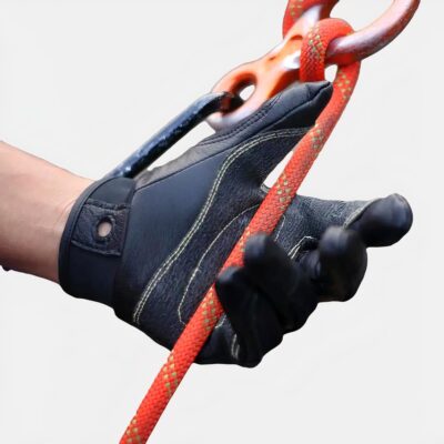Photo d'un gant noir d'escalade en pleine action sur la main gauche d'un homme faisant de l'escalade, une corde rouge sur un mousqueton dans la paume anti-dérapante