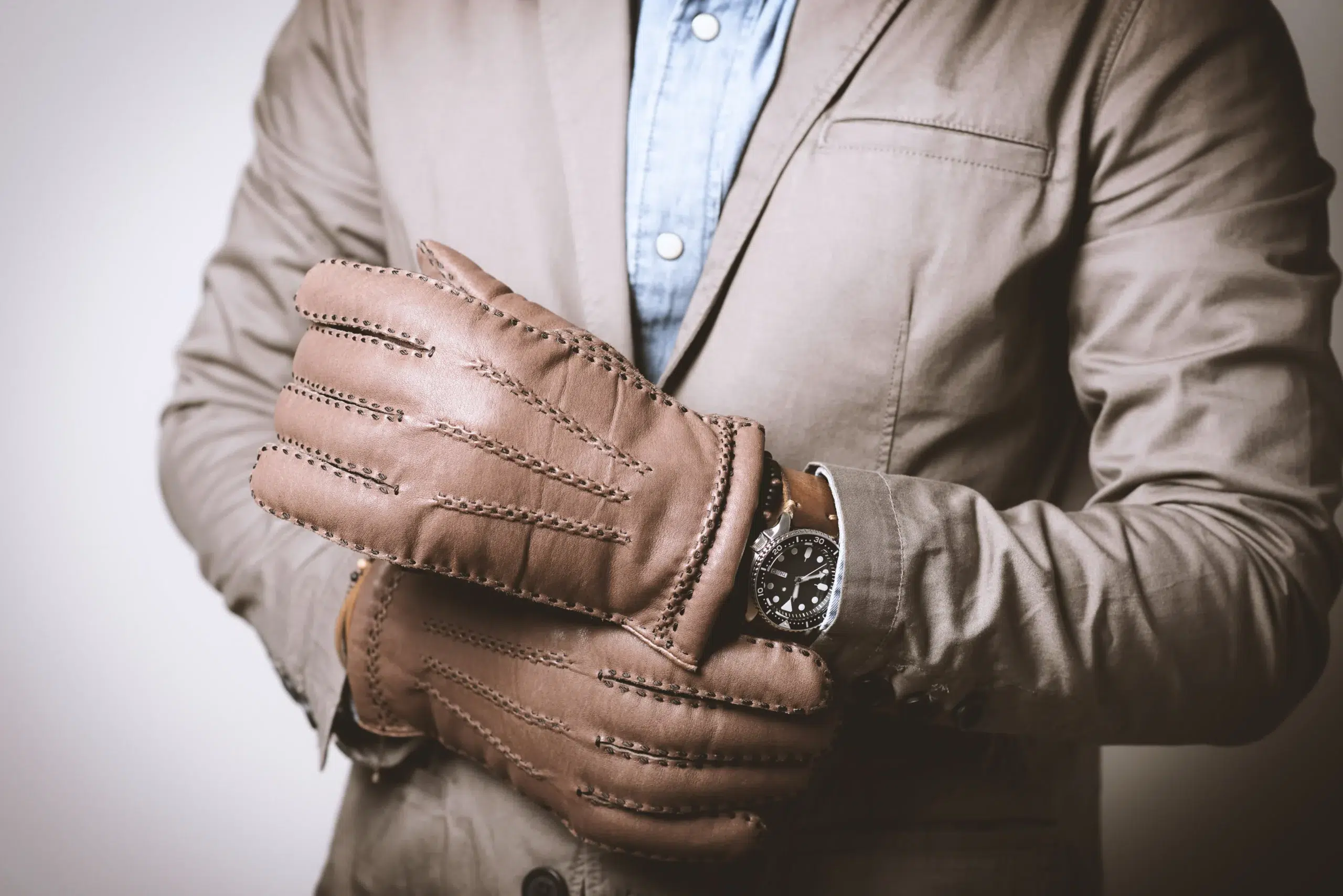 Quelle paire de gants pour homme choisir ? homme qui porte des gants en cuir marron